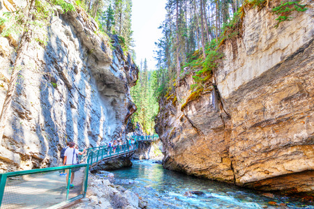 BANFF, CANADA - JUL 30, 2018: Visitors sightseeing at Johnston Canyon of Banff National Park, a popular hiking trail through the walkway on the limestone canyon walls.のeditorial素材
