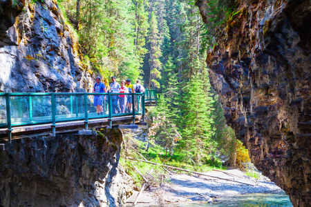 BANFF, CANADA - JUL 30, 2018: Visitors sightseeing at Johnston Canyon of Banff National Park, a popular hiking trail through the walkway on the limestone canyon walls.のeditorial素材