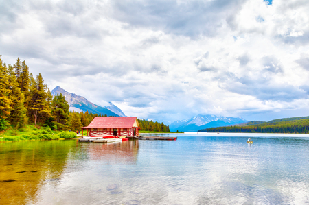 Colorful canoes lie on the boat house dock at Maligne Lake in Jasper National Park, Alberta, Canada. The lake is famous for the surrounding peaks and the three visible glaciers.のeditorial素材