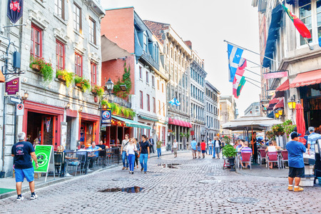MONTREAL, CANADA - AUG 20, 2012: People meander at the junction of Rue Saint-Paul and Rue Saint-Vincent in the Old Montreal section of Montreal. They are the oldest streets in Montreal, Quebec, Canada, famous for the restaurants and unique shops.のeditorial素材