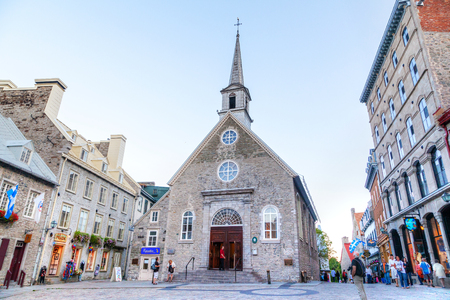 QUEBEC CITY, CANADA - AUG 21, 2012: Tourists meander the cobblestone streets of Place Royale in Old Quebec city, in front of Notre-Dame-des-Victoires (Our Lady of Victories) Church erected in 1688, the oldest stone church in North America. It was declaredのeditorial素材