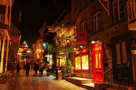 QUEBEC CITY, CANADA - AUG 21, 2012: Tourists meander the Lower Town street of Place Royale at night. The historic district of Old Quebec is a UNESCO World Heritage Site.のeditorial素材
