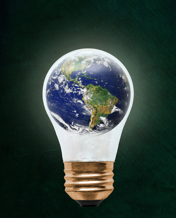Planet earth inside floating light bulb with copy space. Concept of ecology, environmental conservation; green alternativeの写真素材