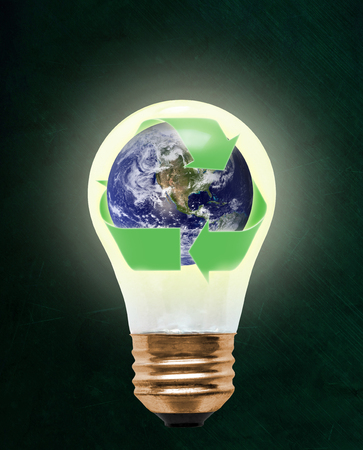 Planet earth wrapped in recycling symbol inside floating light bulb with copy space. Concept of ecology, environmental conservation; green alternativeの写真素材