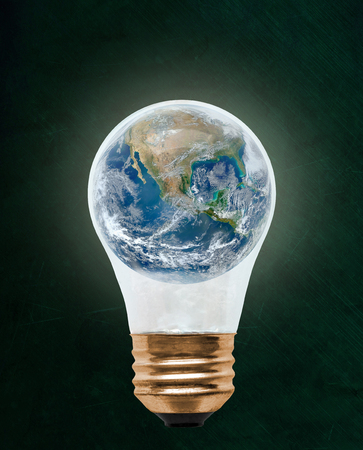 Planet earth inside floating light bulb with copy space. Concept of ecology, environmental conservation; green alternativeの写真素材