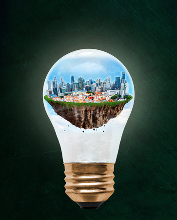 Floating city of Singapore inside light bulb with copy space. Concept of eco-friendly, energy efficient city and idea of environmental conservation in modern green city.の写真素材