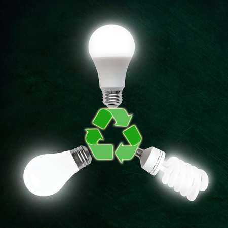 Illuminated light bulbs of LED, CFL fluorescent and incandescent technologies plugged into recycle symbol. Evolution of energy efficient bulb technology good for the environment.の写真素材