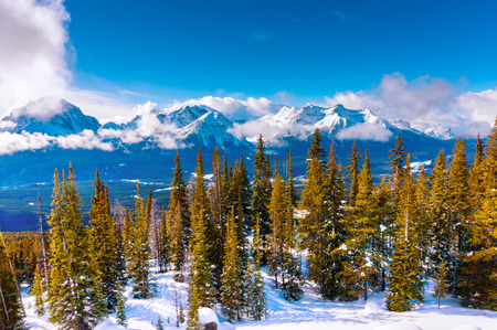 Snowy winter landscape of Lake Louise high up in the Canadian Rockies near Banff National Park, Canada, as low clouds cover the mountain peaks.の写真素材