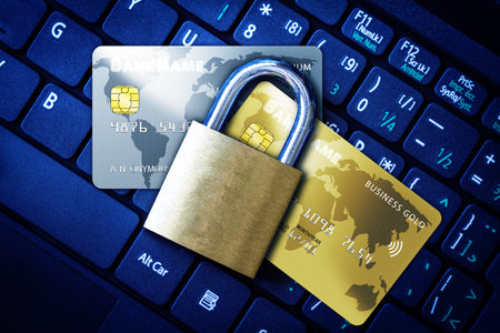 Golden padlock on top of fictitious credit cards on computer keyboard. Concept of Internet security,...
