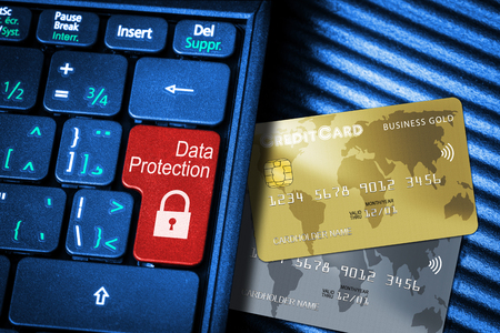 Close up of computer laptop keyboard on generic credit cards with red button Data Protection concept and copy space. Idea of Internet security, data privacy, cyber crime prevention on online transactions.の写真素材