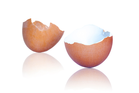 Broken brown egg shells with reflections isolated on white background.の写真素材