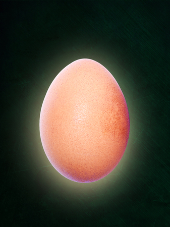 Backlit brown egg floating in midair and isolated on chalkboard background with copy space.の写真素材