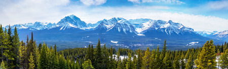 Sweeping vista of the snow-capped mountain landscape showing Mount Victoria glacier of the Canadian Rockies near Banff National Park in Alberta, Canada. The Lake Louise gondola can be seen at left going up the mountains.の写真素材