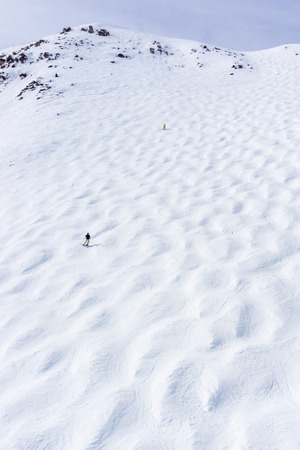 Skiers descending the steep mogul ski hill slope at a mountain in Lake Louise in the Canadian Rockies of Alberta, Canada.の写真素材