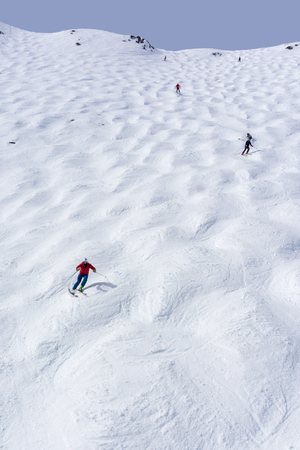 Skiers descending the steep mogul ski hill slope at a mountain in Lake Louise in the Canadian Rockies of Alberta, Canada.の写真素材