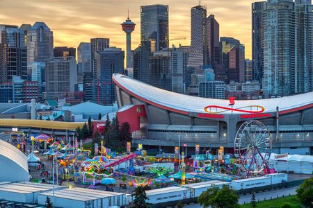 CALGARY, CANADA - JULY 14, 2019: Sunset over Calgary skyline with the annual Stampede event at the Saddledome grounds. The Calgary Stampede is renowned as the greatest outdoor show on Earth.のeditorial素材