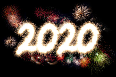 Happy New Year firework display with the Year 2020 lit up in glowing sparkles and light and...