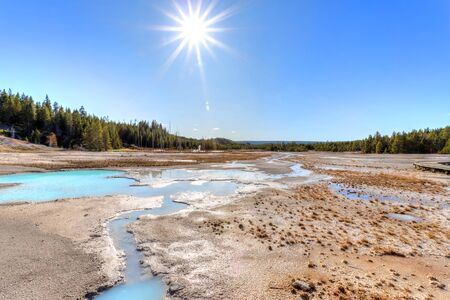 Sun over the geothermal grounds of Porcelain Basin trail at Norris Geyser Basin in Yellowstone National Park, Wyoming, USA.の写真素材