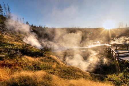 Sunset over Artists Paintpot Trail as steam rises from the geysers and hot springs at Yellowstone National Park  in Wyoming, USA.の写真素材