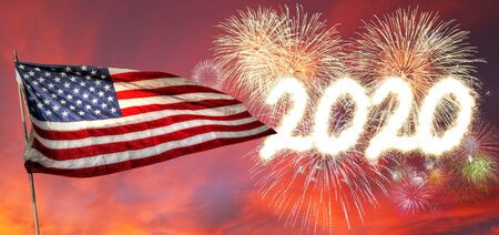 Happy New Year 2020 with fireworks setting off in the sunset background and flying USA Flag.の写真素材