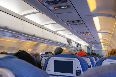 Inside of an airplane cabin with passengers on flight waiting for takeoff.の写真素材