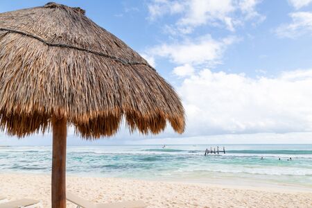 Close up of coconut palm leaf straw beach umbrella against blue skies with copy space in a Cancun beach in Mexico.の写真素材