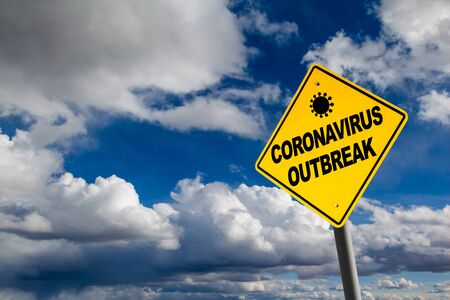Coronavirus outbreak warning against a cloudy blue sky with copy space.の写真素材