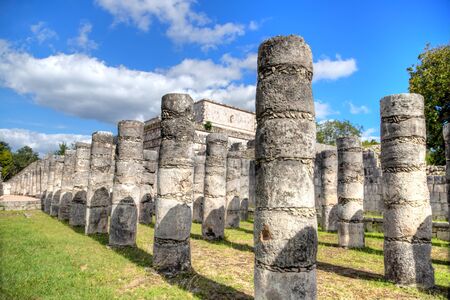 Ancient ruins of Temple of the Warriors at the Mayan archaelogical site of Chichen Itza, Yucatan, Mexico. Its name derives from the pillar columns with relief carvings of warriors. At the top sits a Chac Mool statue.の写真素材