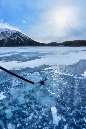 Playing ice hockey on frozen Lake Minnewanka in the Canadian Rockies of Banff National Park,...