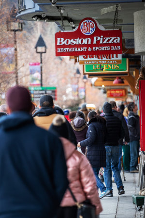 BANFF, CANADA - FEB 15, 2020 : Boston Pizza sign on busy Banff Avenue in Alberta, Canada. The Canadian restaurant chain, also known as BP and The Gourmet Pizza, owns and franchises locations in Canada, the United States and Mexico.のeditorial素材