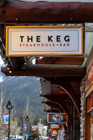 BANFF, CANADA - FEB 15, 2020 : The Keg restaurant with its sign on busy Banff Avenue in Alberta, Canada. The Keg is a Canadian-owned chain of steakhouse restaurants and bars located in Canada and the United States.のeditorial素材