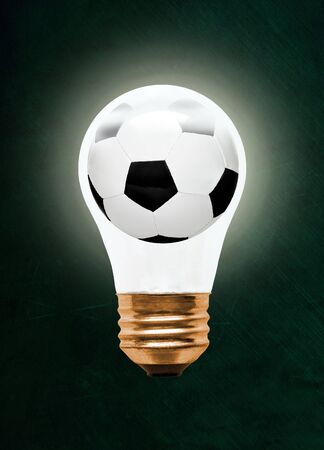 Soccer ball inside glowing light bulb against blackboard with copy space. の写真素材