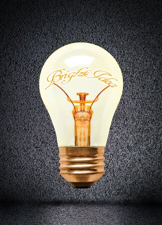 Illuminated light bulb with glowing bright idea text and copy space. Concept of innovation, imagination, inspiration and creativity.の写真素材