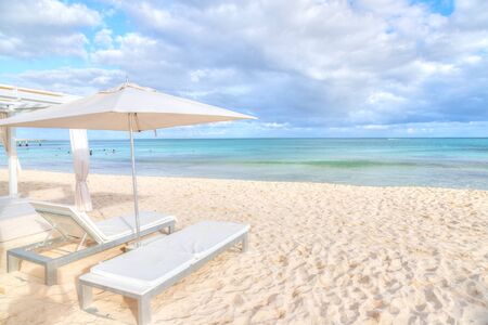 Lounge chair beds and umbrella at white sandy beach in the Caribbean coast of Riviera Maya in Cancun, Mexico.の写真素材