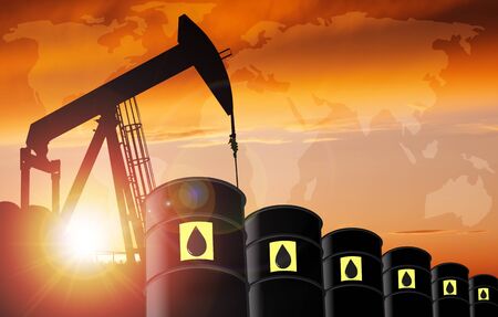 Pump jack silhouette and oil barrel drums against a sunset sky with world map and copy space. Concept of crude oil production and impact on world reliance.の写真素材