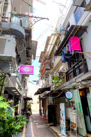 Hong Kong, Hong Kong SAR - July 14, 2017: The narrow alleyway of Sai Kung Main Street is filled with stores and restaurants in this old and famous seaside fishing village in Hong Kong. Vertical orientation.のeditorial素材
