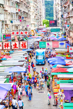 Hong Kong, Hong Kong SAR - July 10, 2017: Shoppers at the Fa Yuen street market under the old crowded housing apartments in Hong Kong. The area is popular with tourists and locals for its cheap food and fashion clothing. Vertical orientation.のeditorial素材