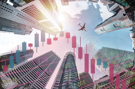 Economic recession concept showing declining stock chart and plane flying over modern business skyscraper buildings in Singapore's financial district.の写真素材