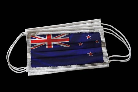 Multiple surgical face masks with New Zealand flag printed. Isolated on black background. Concept of face mask usage in the New Zealander effort to combat Covid-19 coronavirus pandemic.の写真素材
