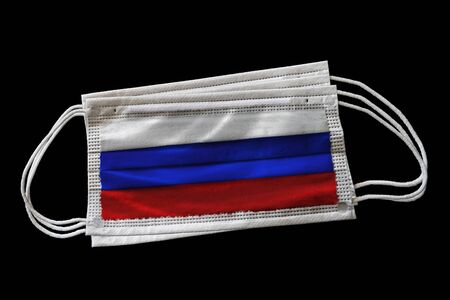 Surgical face masks with Russia flag printed. Isolated on black background. Concept of face mask usage in the Russian effort to combat Covid-19 coronavirus pandemic.の写真素材