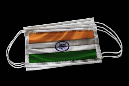 Surgical face masks with India flag printed. Isolated on black background. Concept of face mask usage in the Indian effort to combat Covid-19 coronavirus pandemic.の写真素材