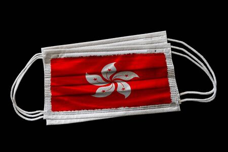 Surgical face masks with Hong Kong flag printed. Isolated on black background. Concept of face mask usage in Hong Kong SAR effort to combat Covid-19 coronavirus pandemic.の写真素材