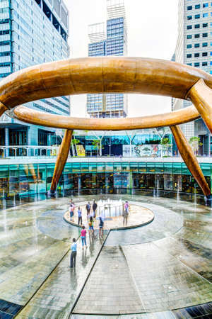 SINGAPORE - MARCH 26, 2015 : Tourists walk toward the Fountain of Wealth believed to impart luck to anyone encircling it 3 times and touching the water in the middle. The largest fountain in the world is located in the commercial complex of Suntec City, Sのeditorial素材
