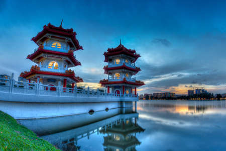 Sunset over the Twin Pagodas at Chinese Garden lake, a public park in Jurong, Singapore.. The free garden is open to general public and modeled after the Chinese imperial style of architecture and landscaping.のeditorial素材