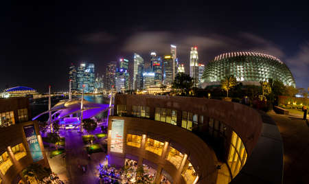SINGAPORE - JULY 16, 2015: The Esplanade Theater at night with Singapore skyline in the background. The iconic building on Marina Bay contains a concert hall, a public library and a shopping mall.のeditorial素材