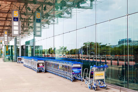 SINGAPORE - MARCH 24, 2015: Luggage carts line the empty entrance to Changi Airport Terminal 3 departure hall.のeditorial素材