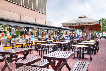 SINGAPORE - APRIL 7, 2011: Visitors dining at Makansutra Gluttons Bay in Singapore, a popular culinary hotspot that serves cheap local street food in an outdoor environment next to the famous Marina Bay.のeditorial素材