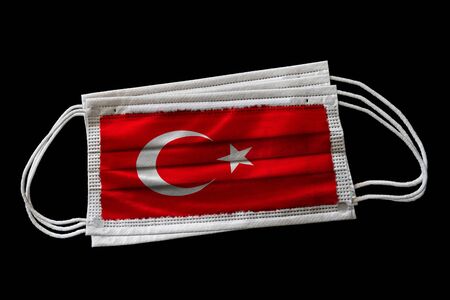 Surgical face masks with flag of Turkey printed. Isolated on black background. Concept of face mask usage in the Turkish effort to combat Covid-19 coronavirus pandemic.の写真素材