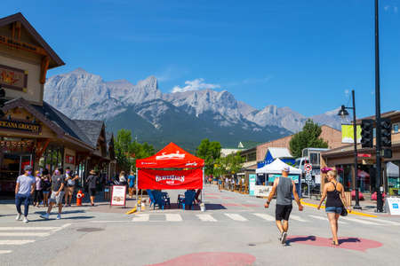 CANMORE, CANADA - JULY 30, 2020: Tourists walking and dining along popular downtown Canmore in the Canadian Rockies. The road was closed to traffic due to COVID-19 to allow for more social distancing among visitors.のeditorial素材