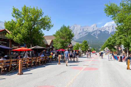 CANMORE, CANADA - JULY 30, 2020: Tourists walking and dining along popular downtown Canmore in the Canadian Rockies. The road was closed to traffic due to COVID-19 to allow for more social distancing among visitors.のeditorial素材